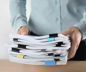 man holding a stack of home offers