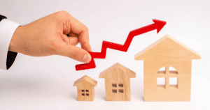 REALTOR holding upwards arrow above wooden houses